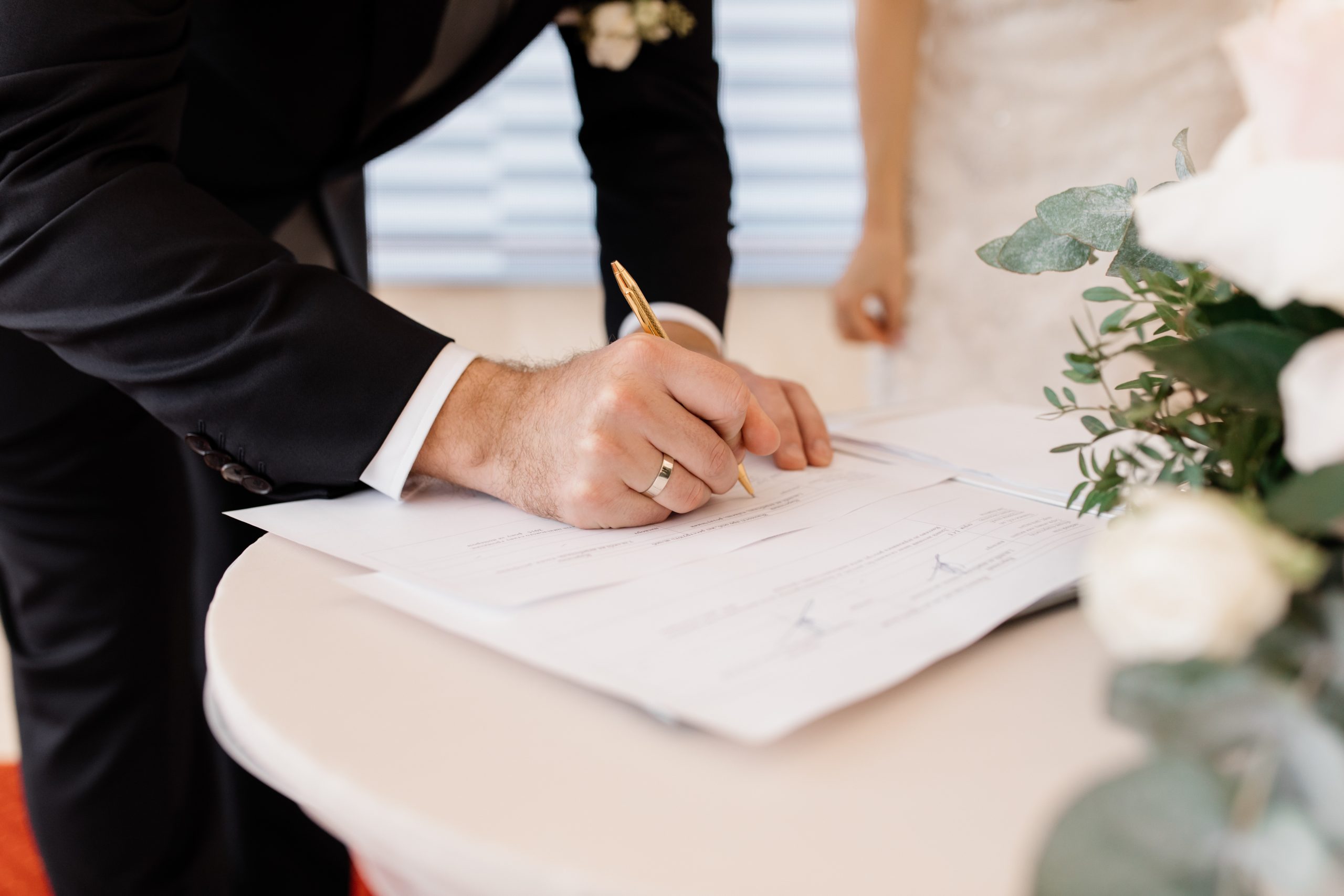 la coppia innamorata sta firmando i documenti di matrimonio ufficiali scaled