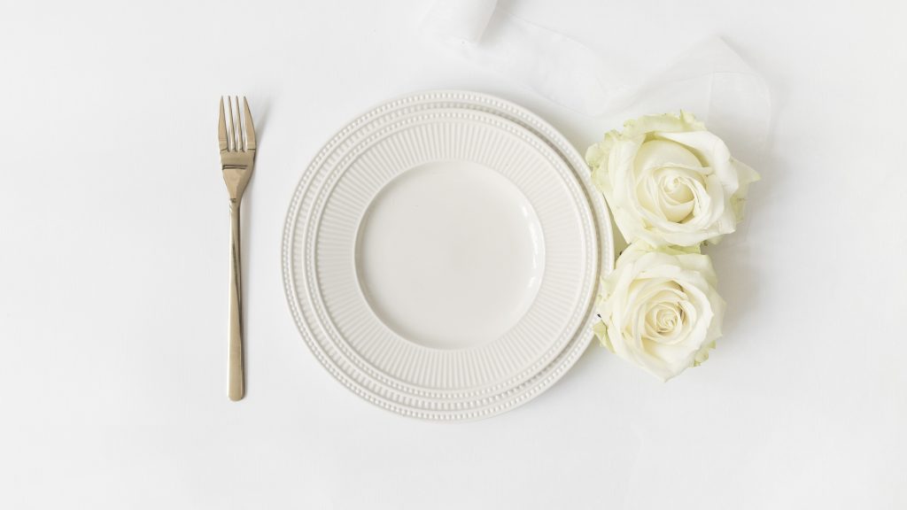 forchetta piatto di ceramica rose e nastro di raso su sfondo bianco