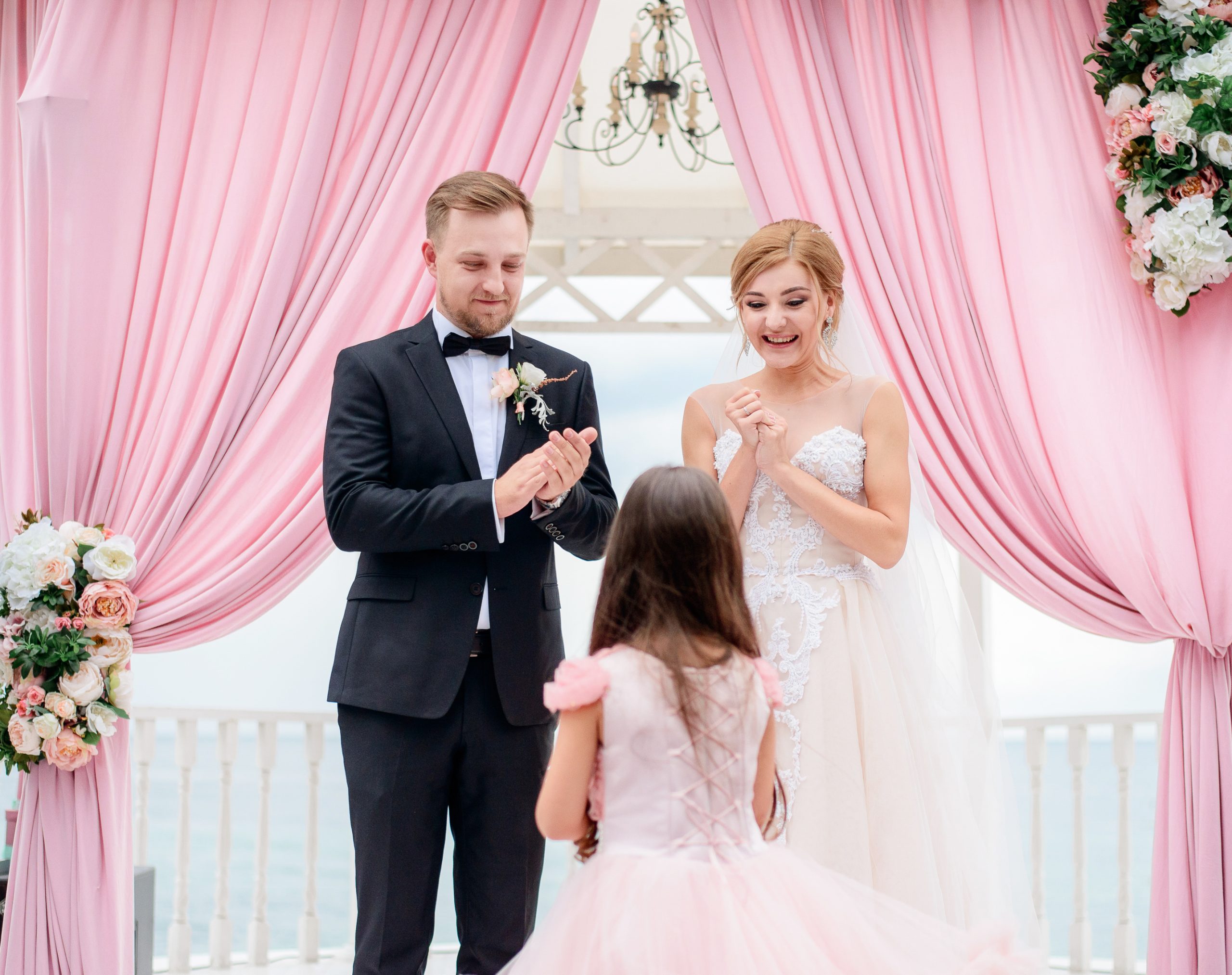 la bambina arriva alla sposa e allo sposo con le fedi durante la cerimonia scaled